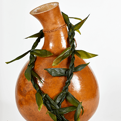 Hawaiian gourd with a ti leaf lei decoration.