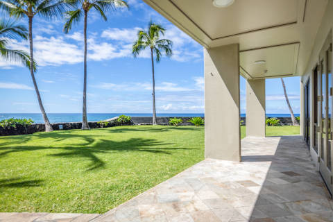Resort exterior from ground level looking at the green lawn and coconut trees