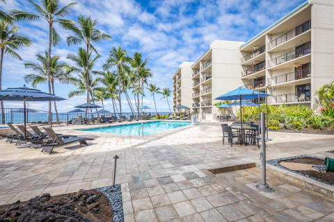 View of the pool deck at ground level with the ocean and hotel in the background