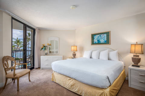 Room with bed, table, chairs, nightstand, lamp, balcony