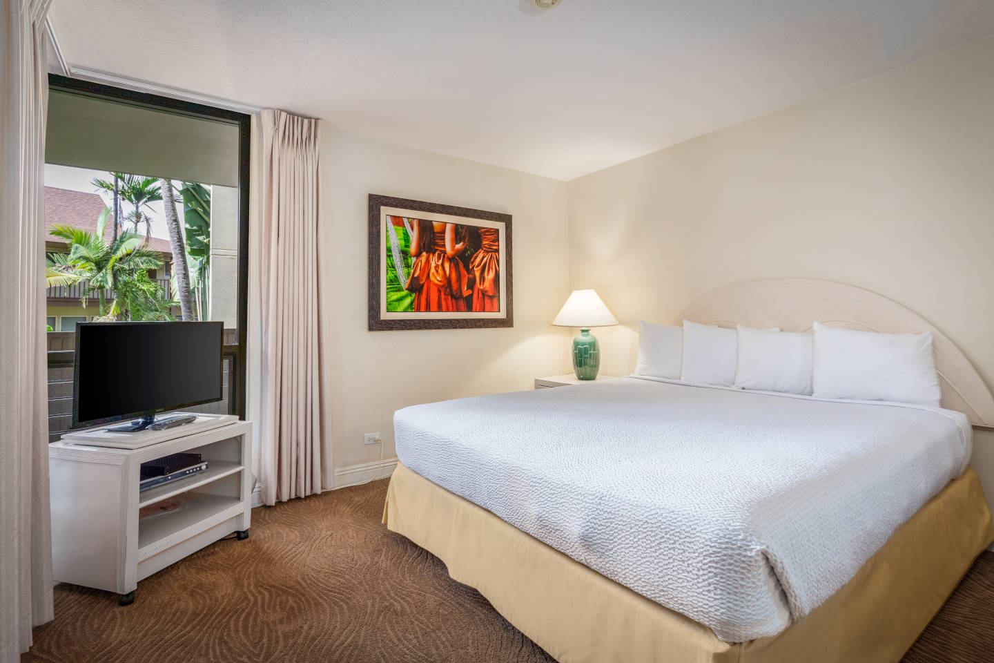 Room with bed lamp, TV, balcony.