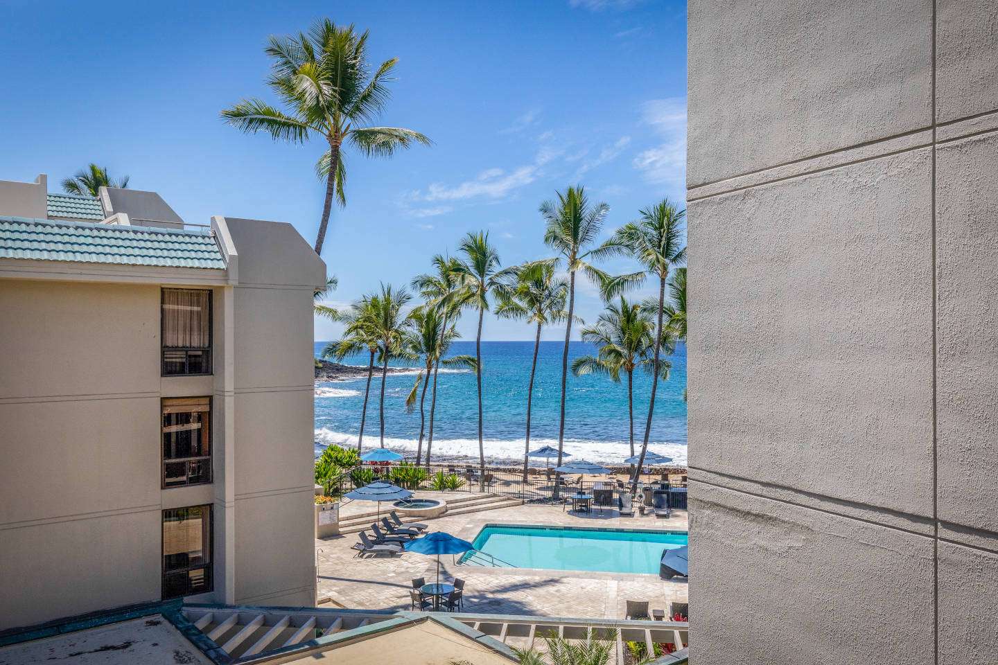 View of pool and ocean from balcony.