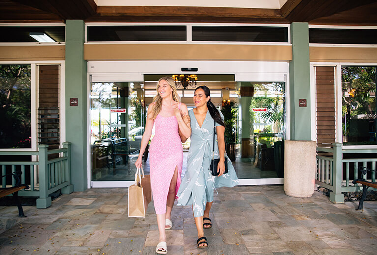 2 women walking through hotel entrance.