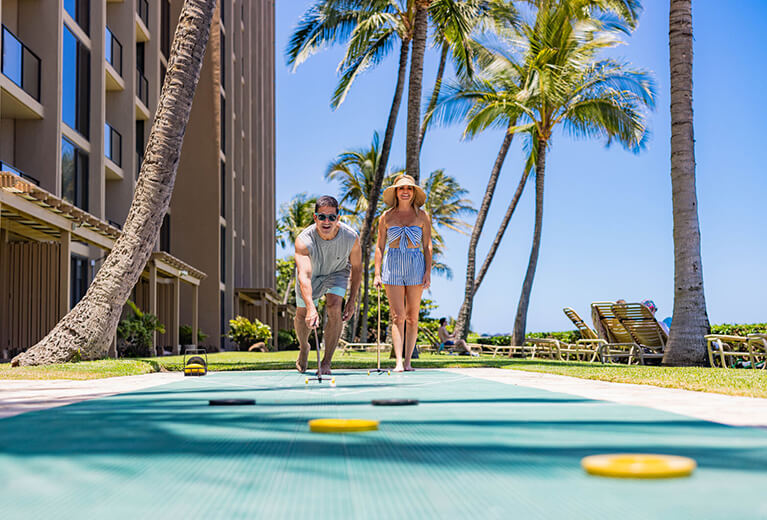 Guests playing outdoor shuffleboard.