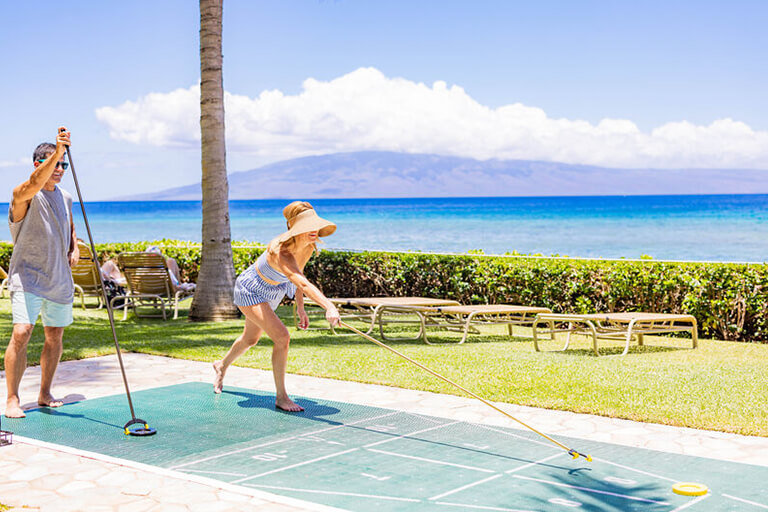 Couple playing shuffleboard.