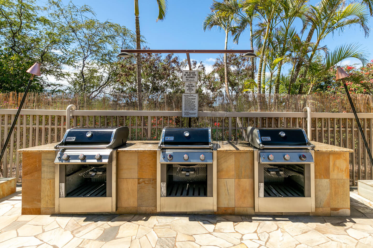 Three outdoor barbecue grills on deck.