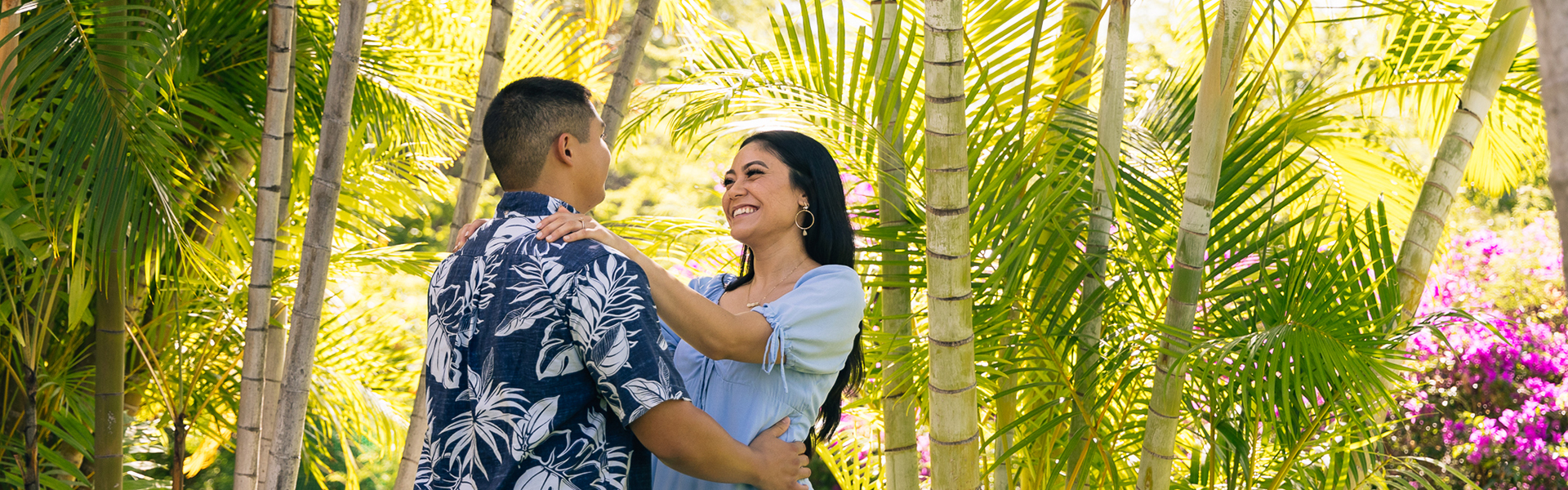 Couple embracing beneath trees in resort gardens