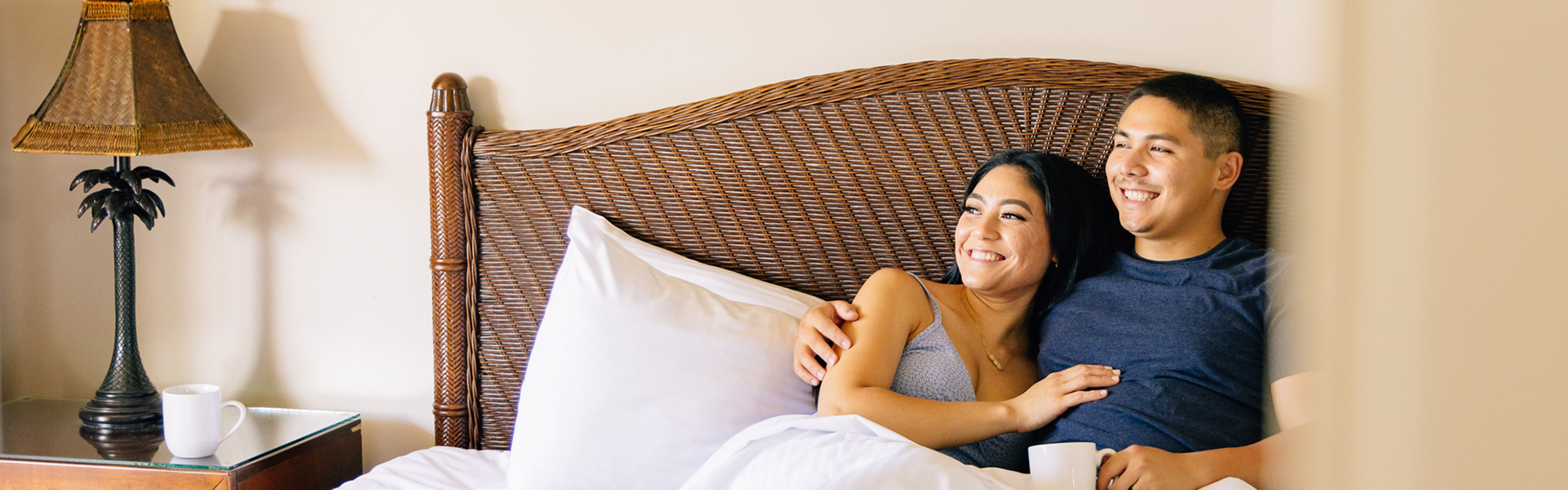 Couple relaxing bed drinking coffee