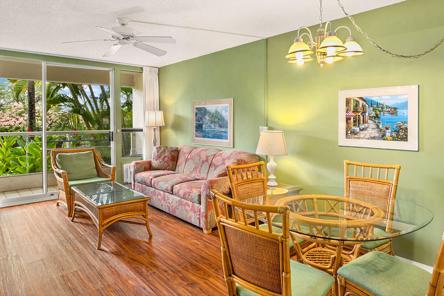 Living area with a couch, TV, lamps, coffee table, dining area, and balcony.