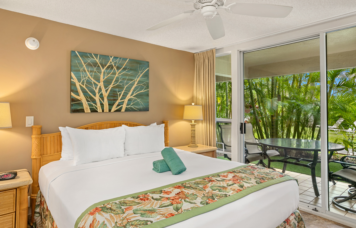 Room with a bed, nightstand, lamps, balcony.