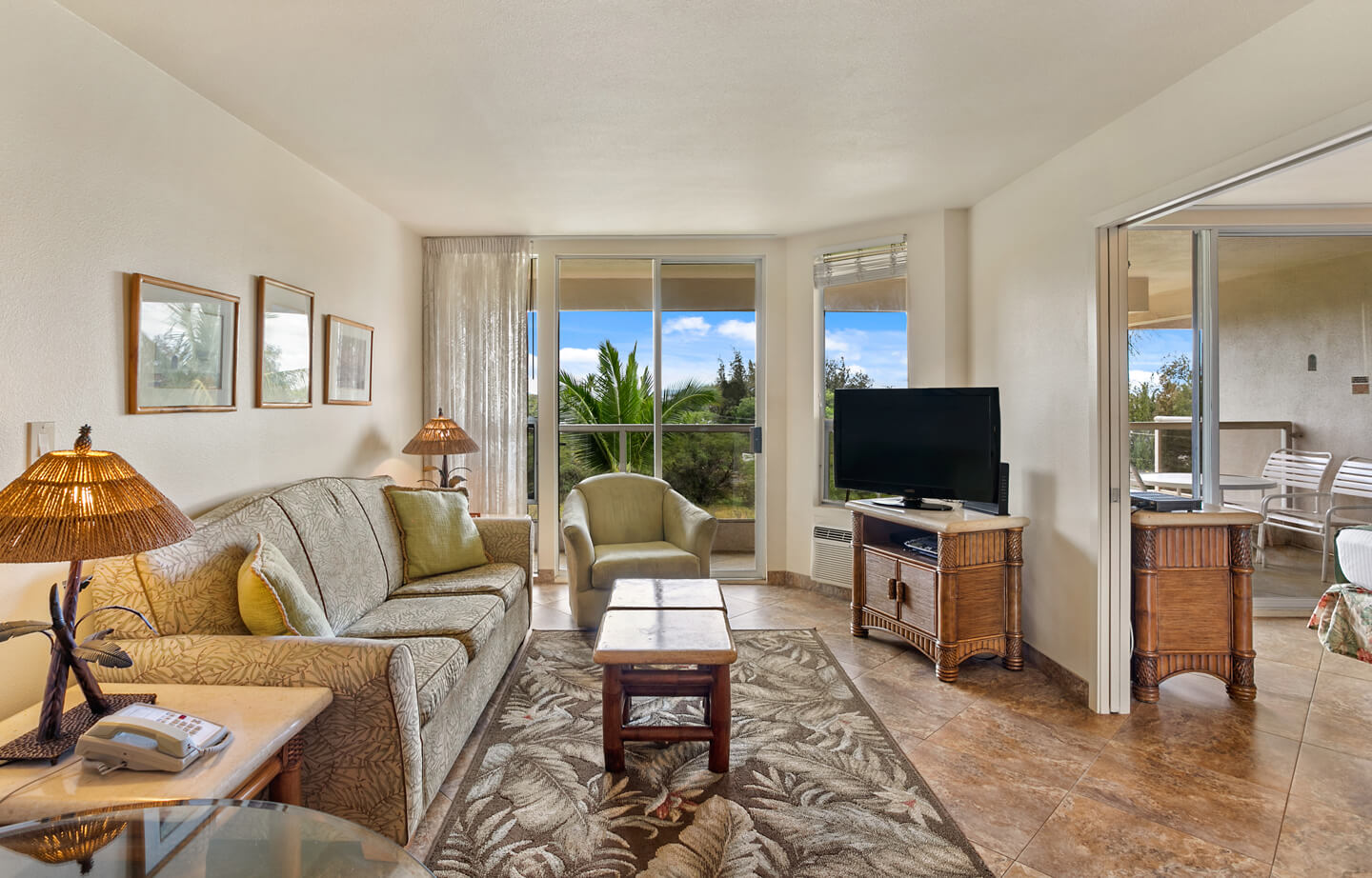 Living area with couch, seating, coffee table, TV, balcony.