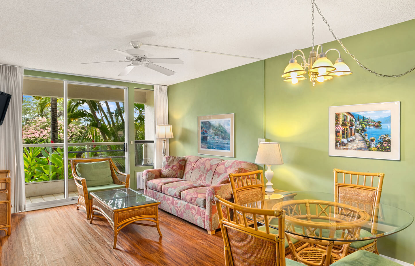 Living area with couch, coffee table, dining table, chairs, TV, balcony.
