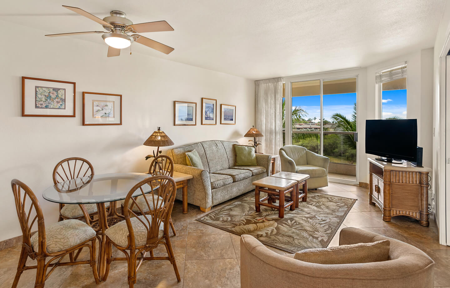 Living room with dining table, chairs, couch, coffee table, TV, balcony.