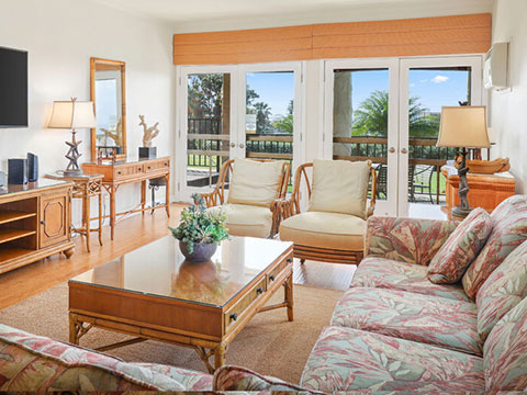 Living room with couch, table, TV, and balcony