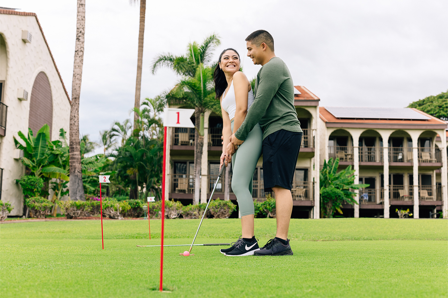 Couple playing on putting green.