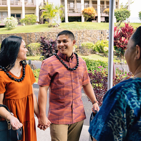 A woman and man are greeted by hotel representative.