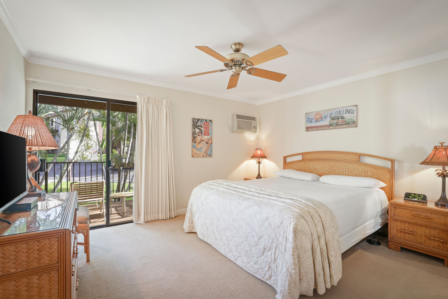 Bedroom with a balcony and seating, night stands, lamps, dresser, TV.
