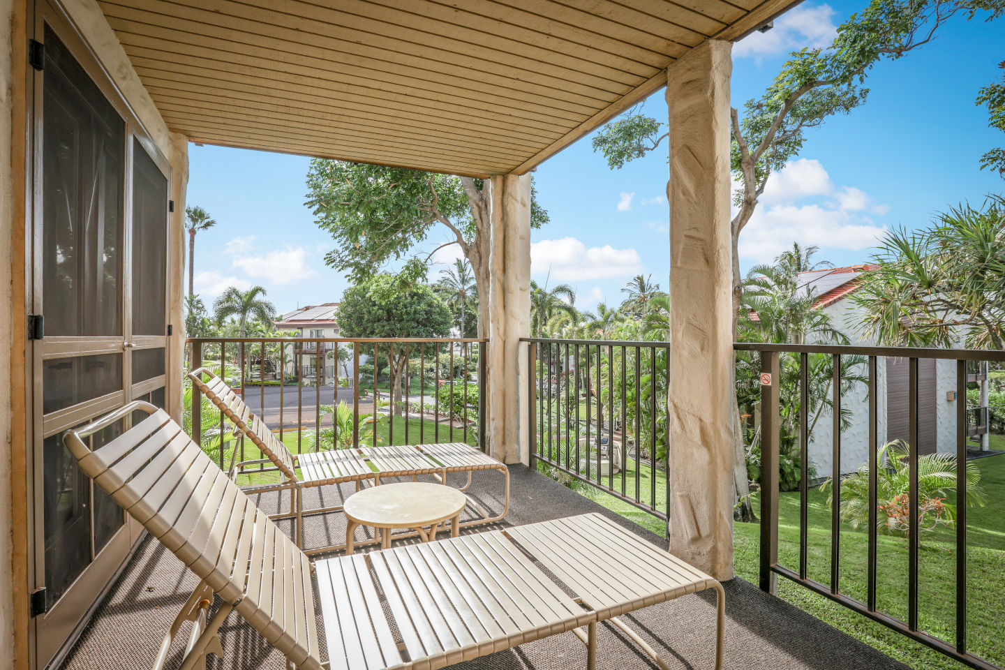 Balcony with lounge chairs and table.