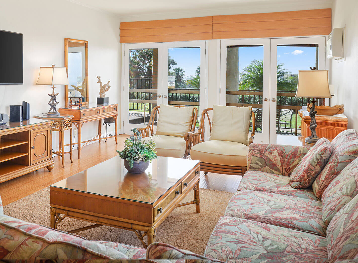 Living room with couch, table, TV, and balcony