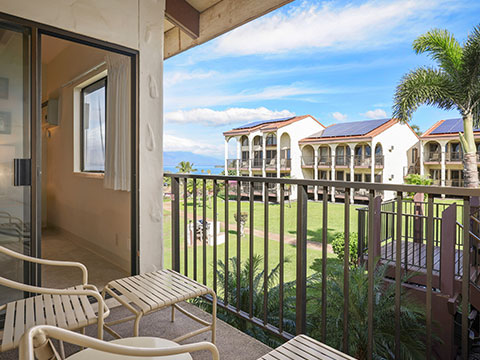 Balcony with table, chairs, views of resort and ocean.