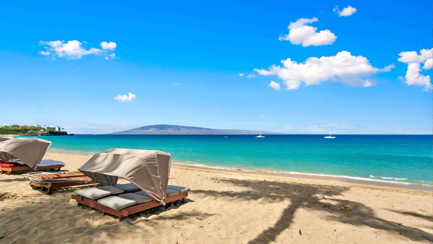 Cabanas on sandy beachfront with views of neighbor island