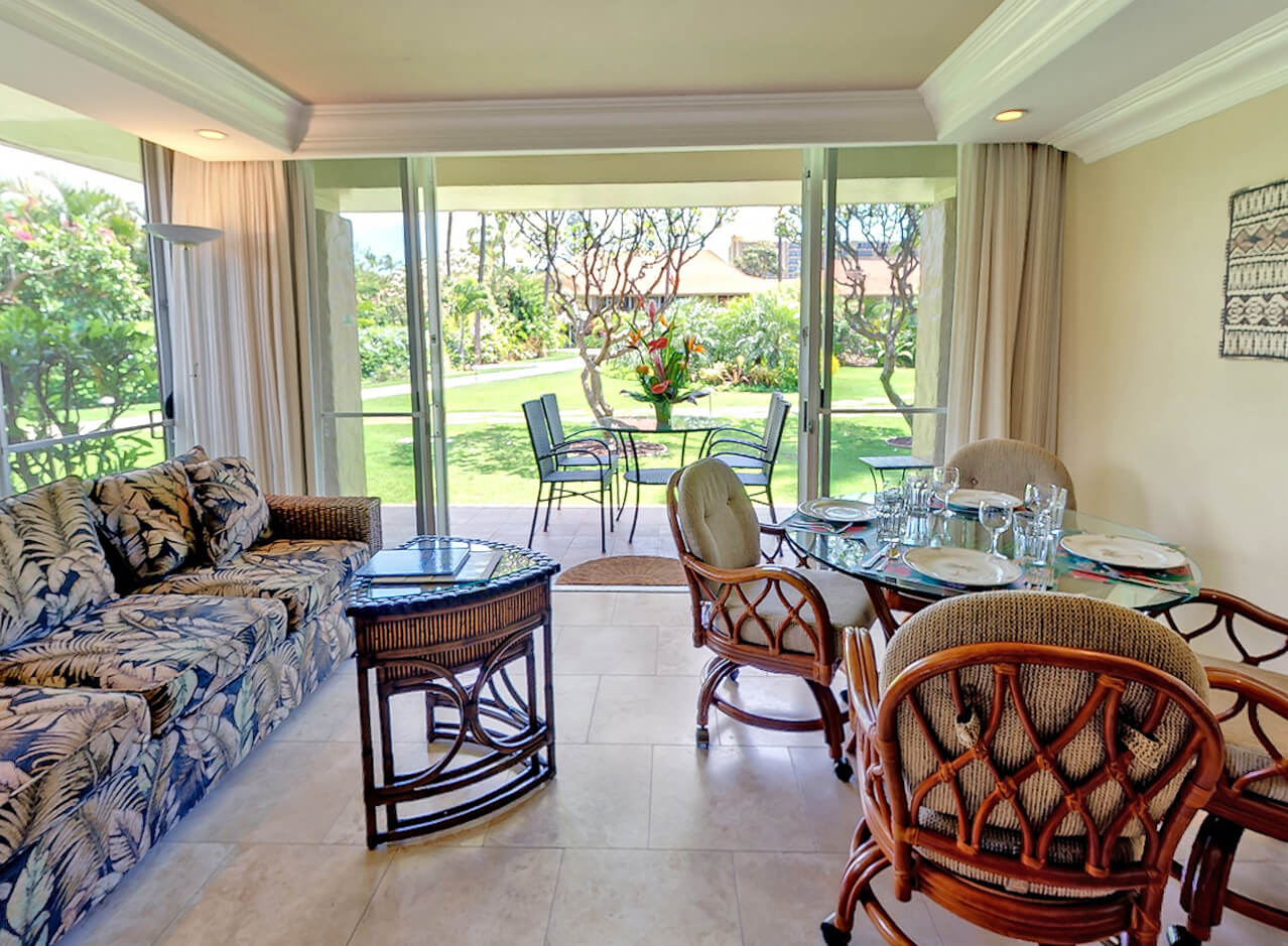 Living area with a couch, dining area, and balcony.