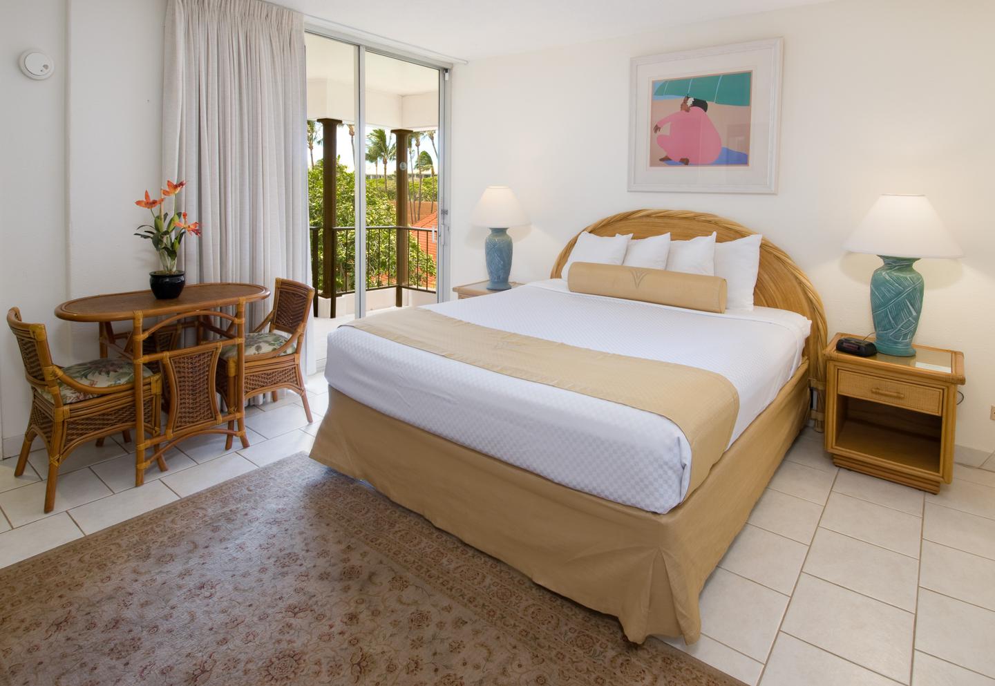 Room with a bed, lamp, and dining table with chairs.