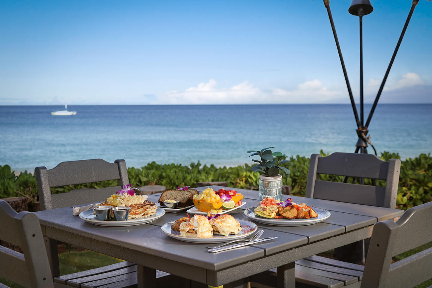 Table with a view of the beach set with food and drinks from the restaurant