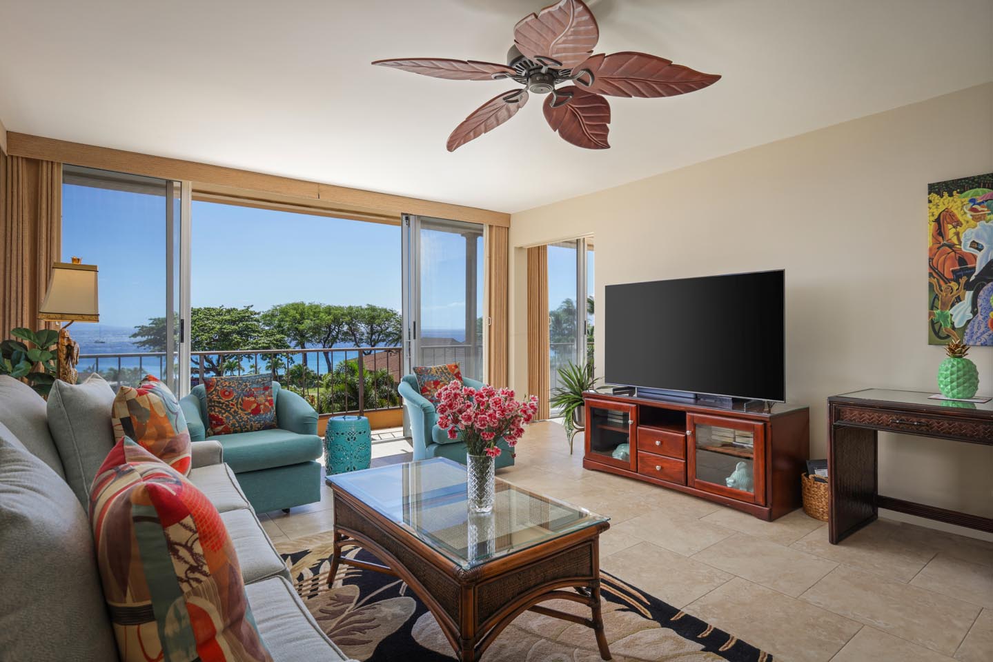 Living area with a couch, coffee table, TV, and balcony.
