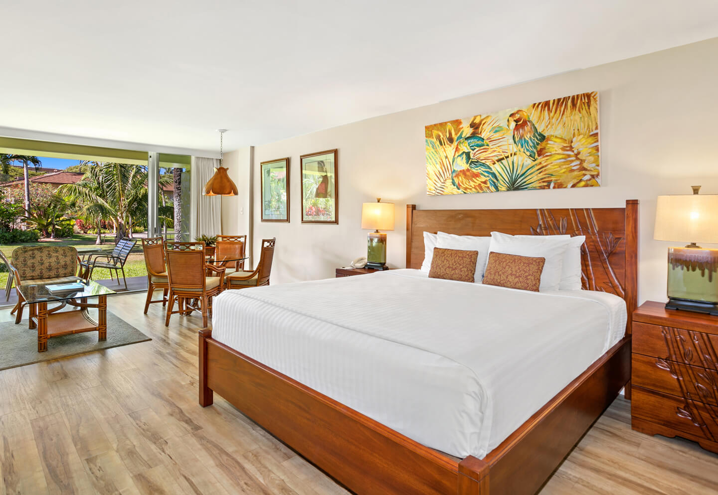 Room with a bed, night stand, lamps, dining area, and patio.