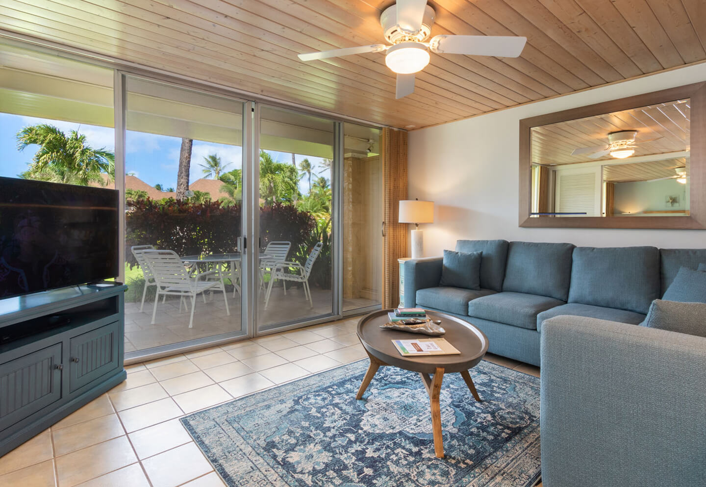 Living room with a couch, coffee table, TV, and balcony.