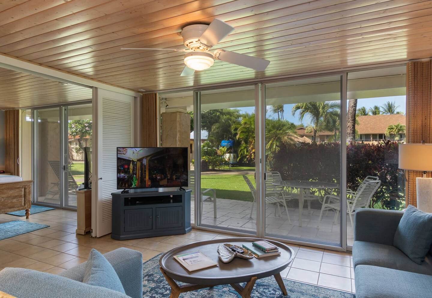 Living room with a couch, coffee table, TV, and balcony.