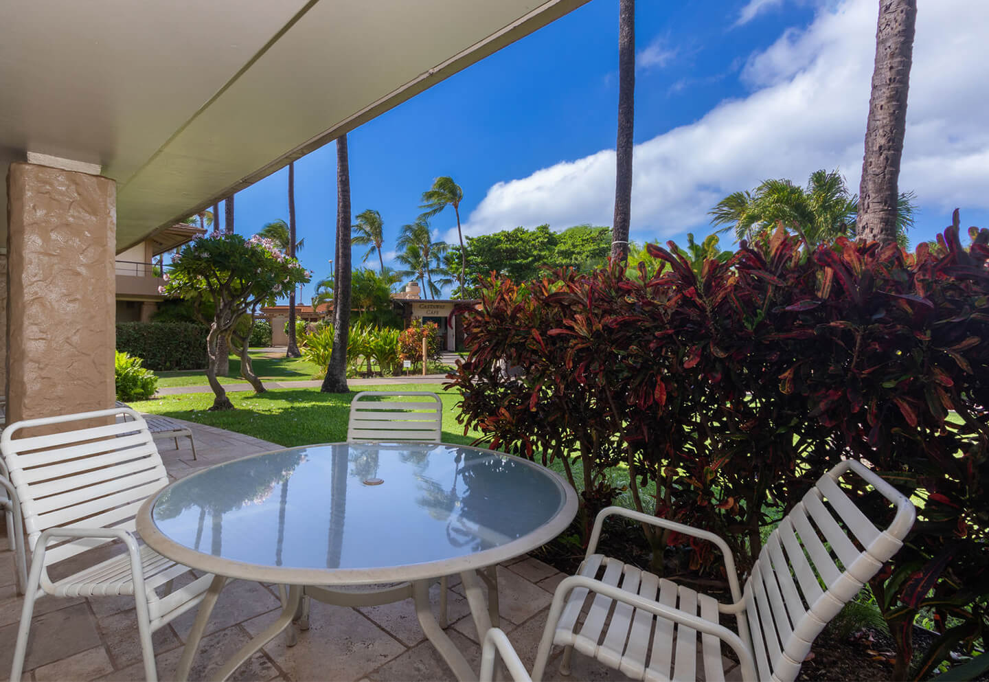 Patio with garden view, table, and chairs.