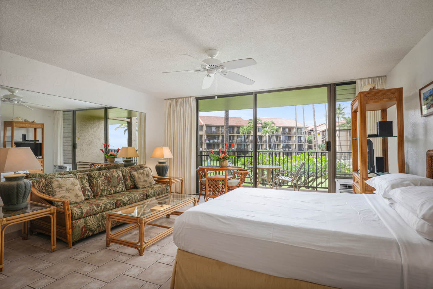 Room with bed, couch, coffee table, lamp, balcony.