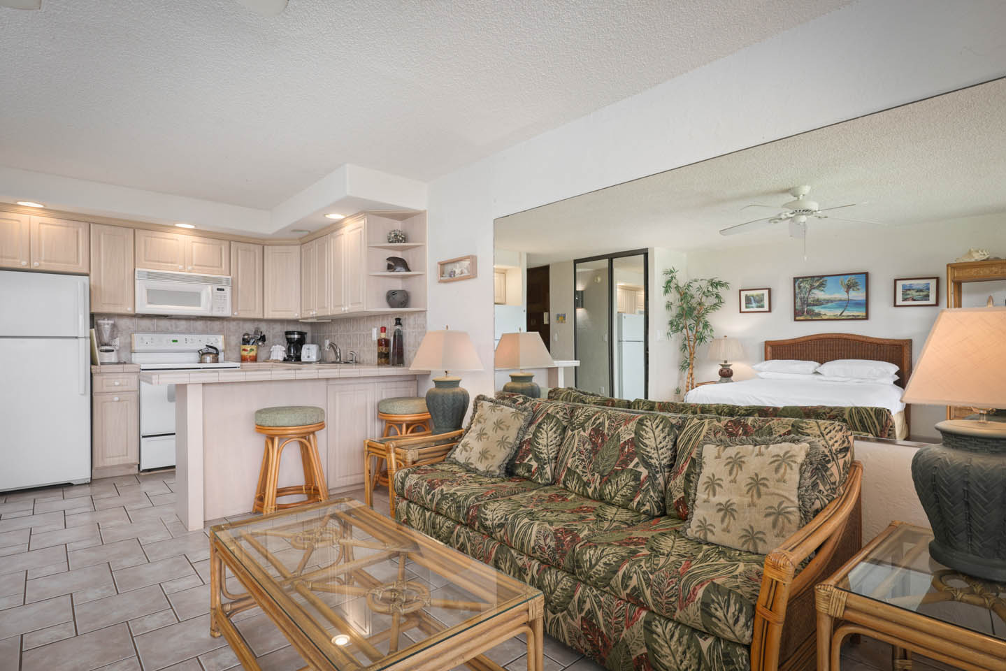 Living area with couch, coffee table, kitchen in background.
