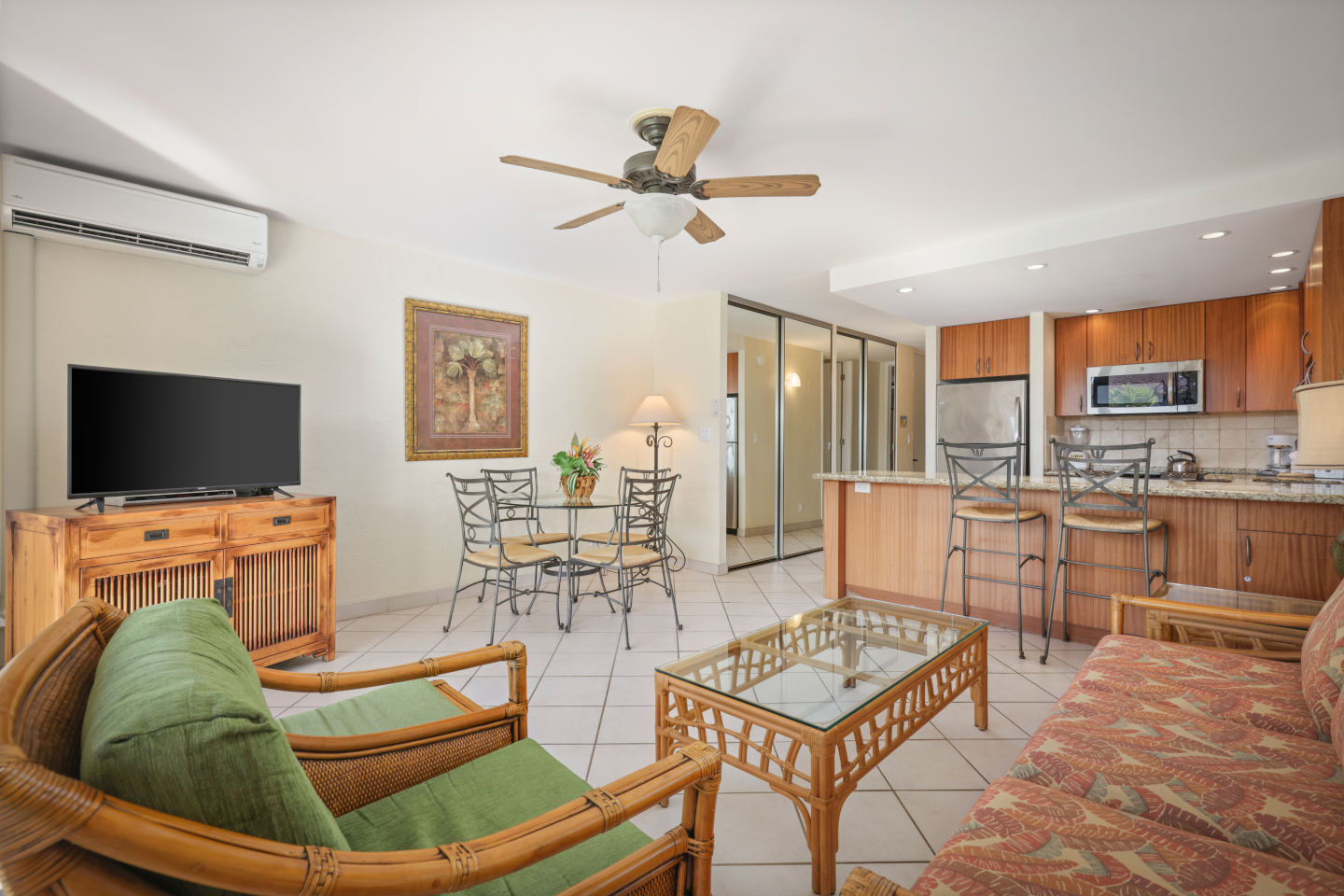 Living area with couch, seating, coffee table, TV, kitchen and dining area.