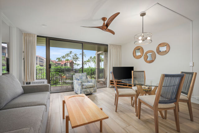 Living room with couch, coffee table, TV, balcony