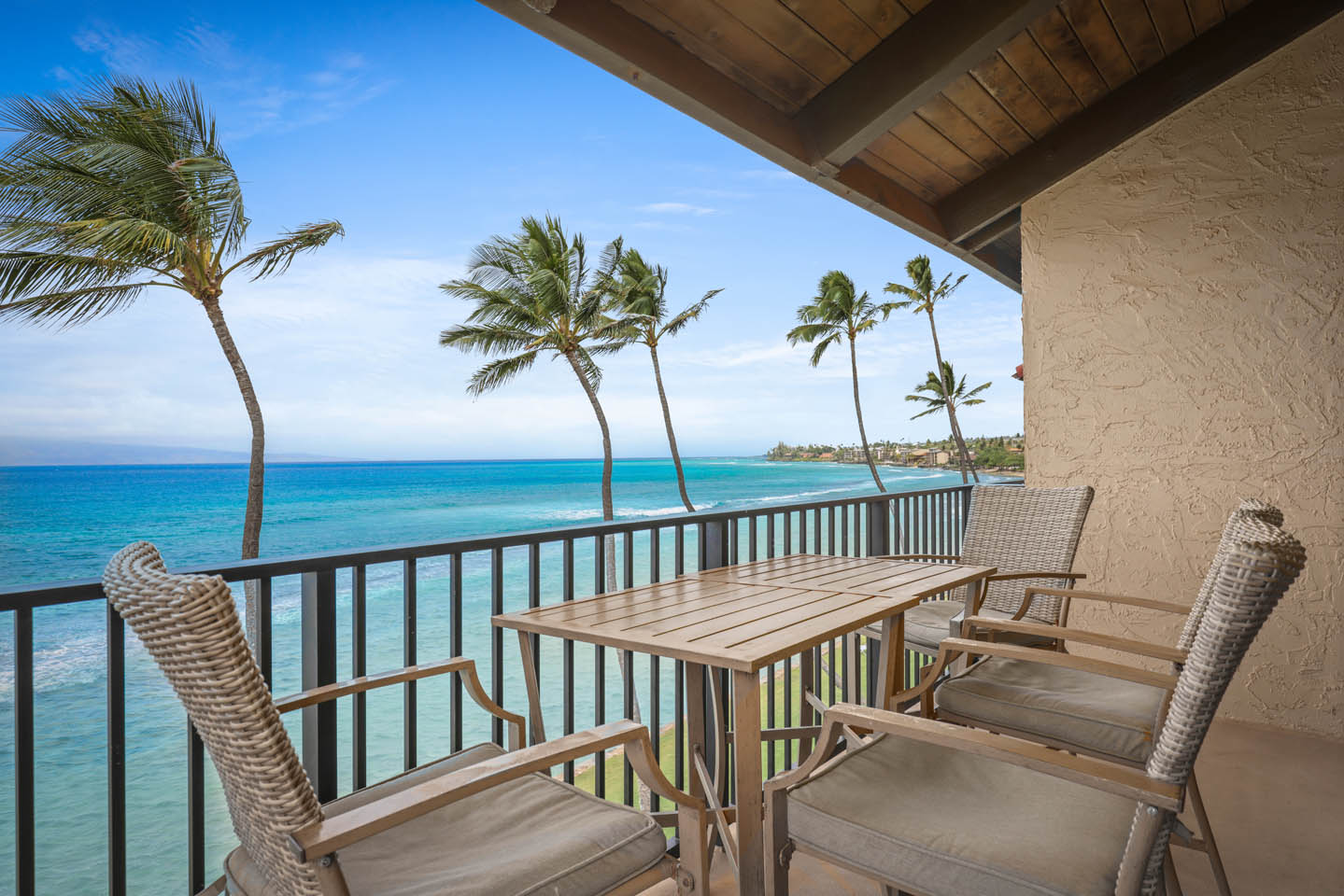 Balcony with table, chairs, and full ocean view.