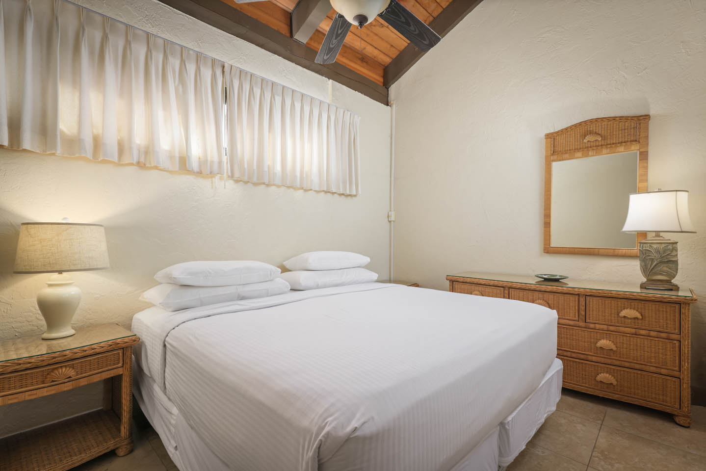 Room with a bed, nightstand, dresser, and lamps.