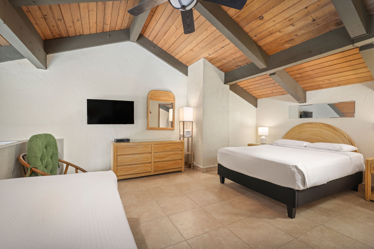 Loft room with bed, TV, lamps, dresser.