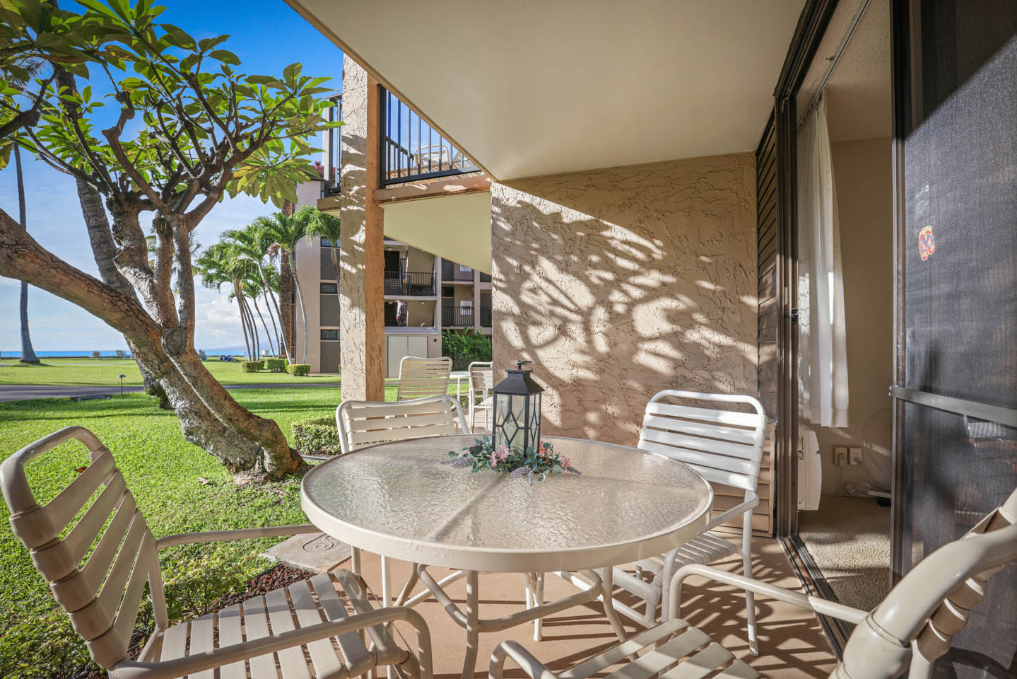 Balcony with table, chairs, garden view.