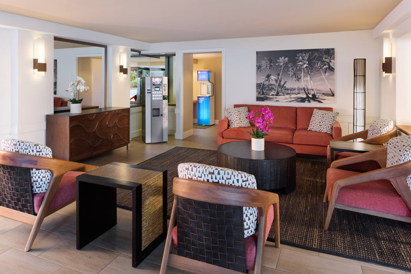 Lobby seating area with table, chairs, lamps.