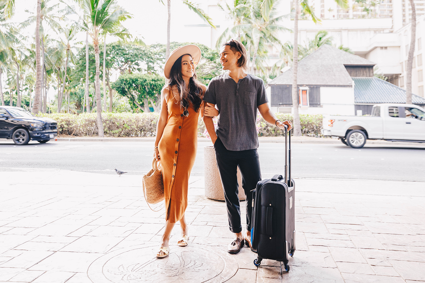 Couple with luggage entering hotel.