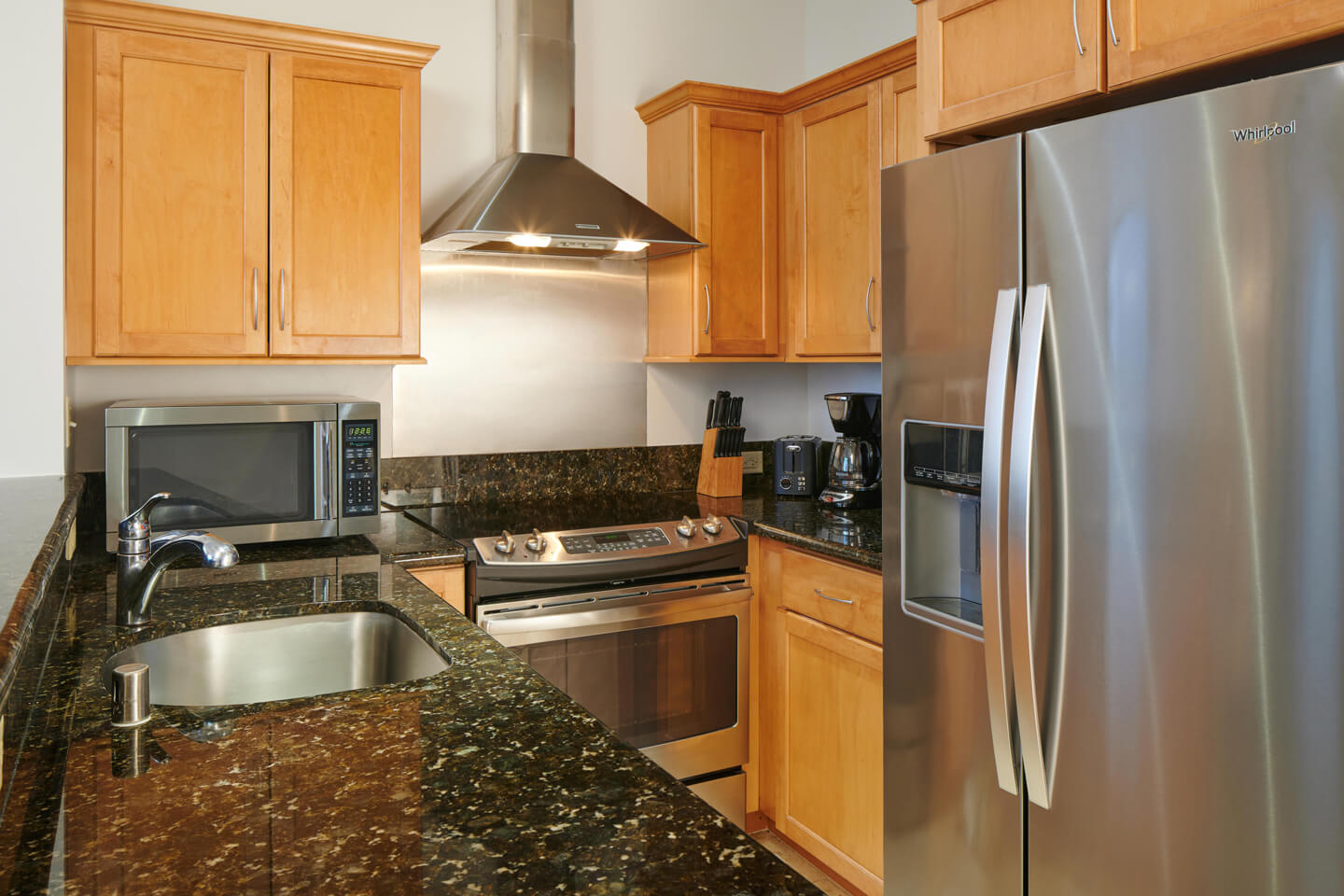 Kitchen with a sink, refrigerator, microwave, stove.