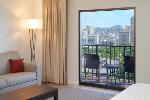 Room with couch, coffee table, lamp, balcony