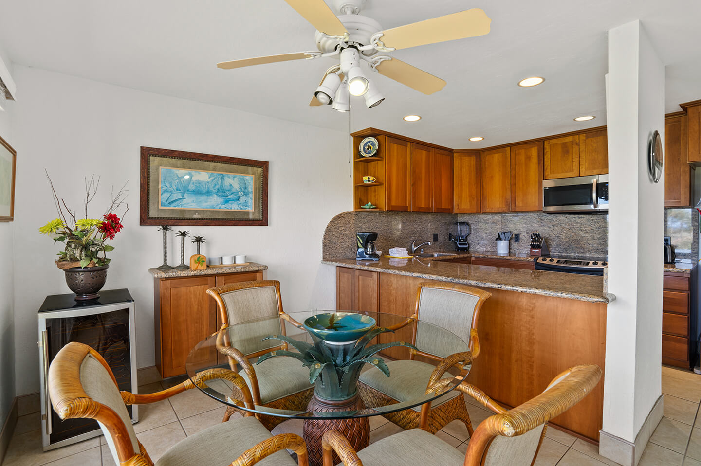 Dining area with table and chairs, full kitchen in background.
