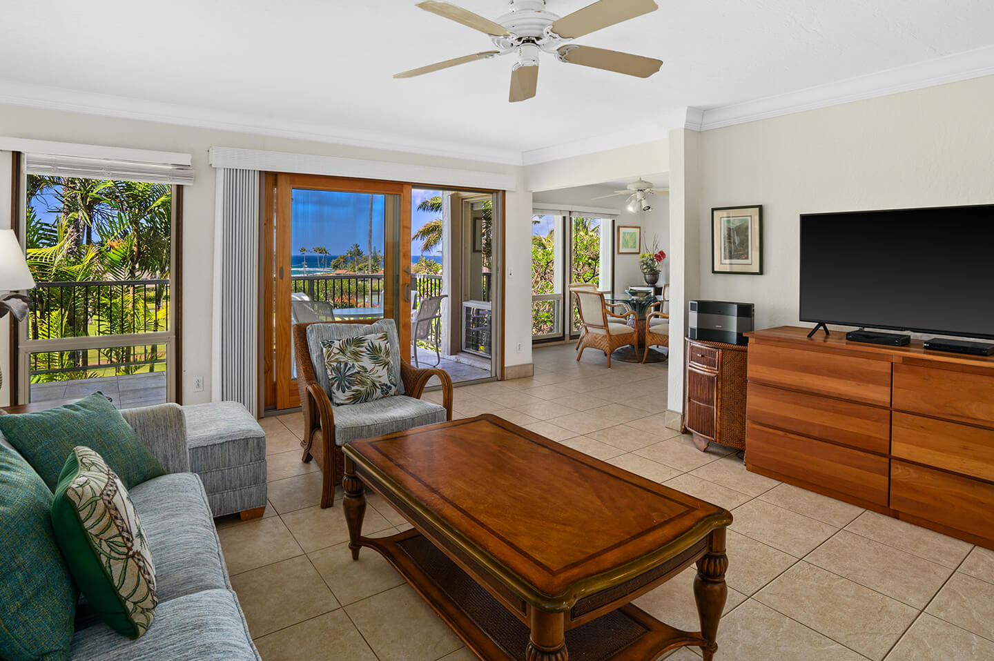 Living area with couches, table, TV, and balcony.