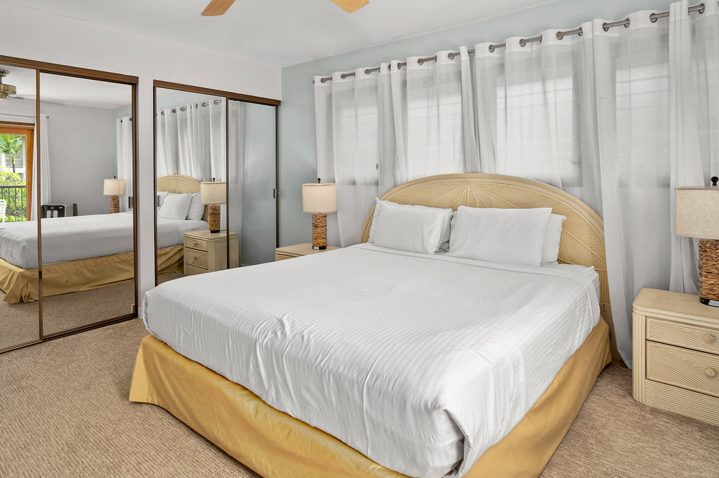 Room with bed, TV, dresser, lamp, balcony.