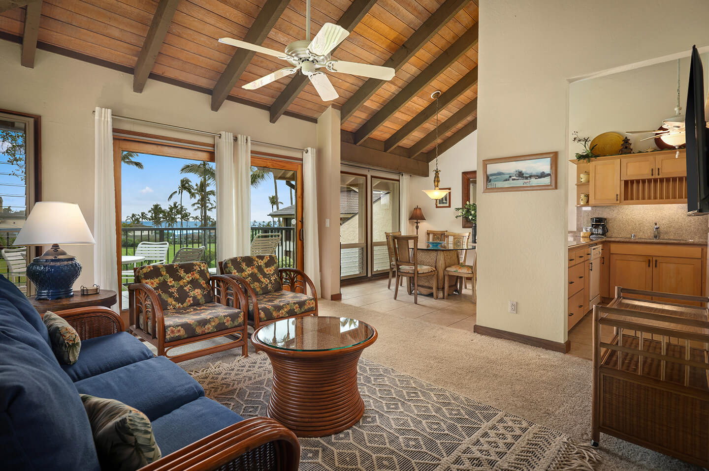 Living area with couches, table, TV, balcony.