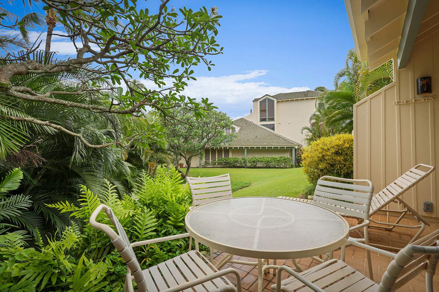 Patio with garden view, tables, and chairs.